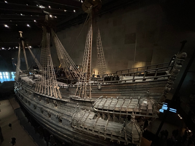       Historic wooden ship displayed inside a museum.
  