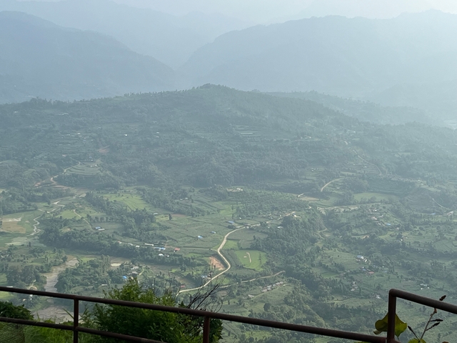       Aerial view of green hills and farmland.
  