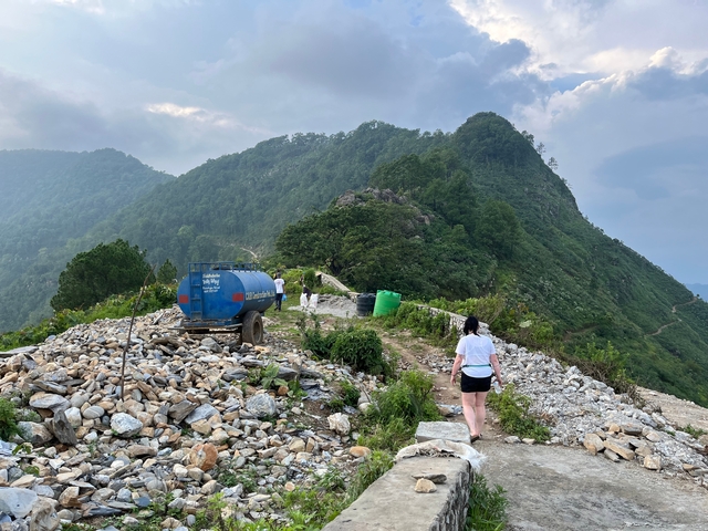       Hikers on a mountain path with scenic view.
  
