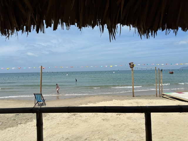 Beach view with a chair and colorful flags.