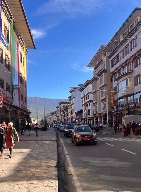       A busy street with traditional buildings and people walking.
  