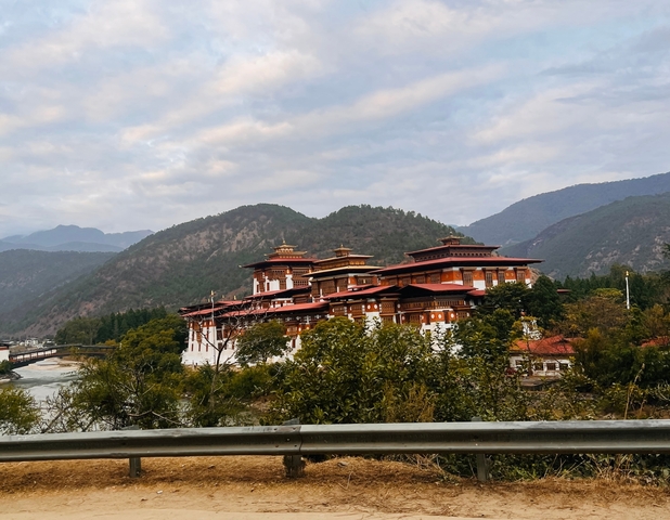       Large monastery surrounded by mountains and trees.
  