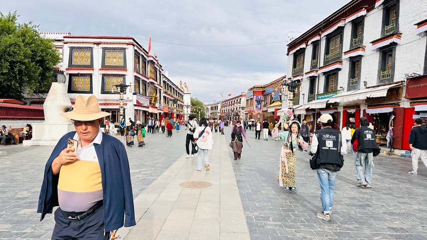 Busy street with people and traditional architecture.