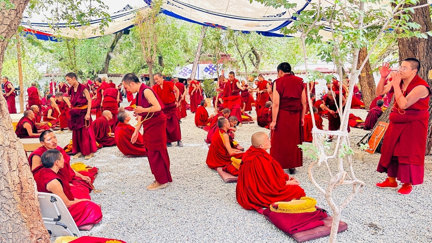 Group of monks gathered under a tent.