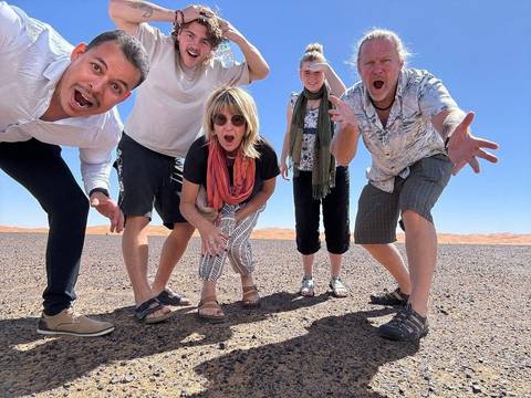 Group of people making funny faces in a desert environment.
