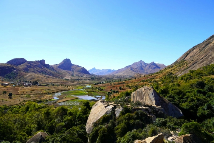 Vast valley with rivers, mountains, and clear skies.