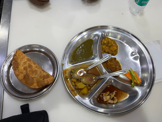       Plate of traditional Indian food served in a steel thali.
  