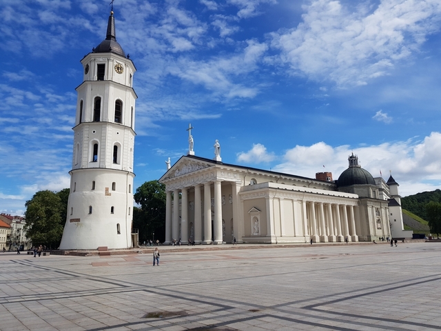       The Vilnius Cathedral and Bell Tower in a square with a clear sky.
  