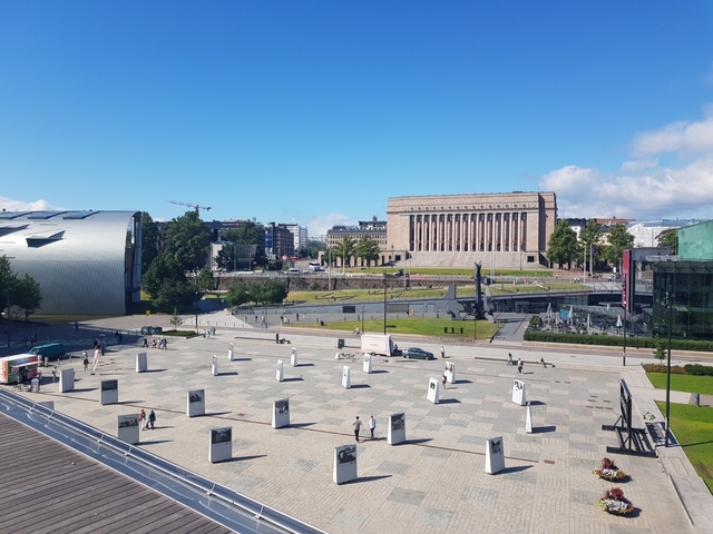       A panoramic view of Helsinki's cityscape with a square and buildings.
  
