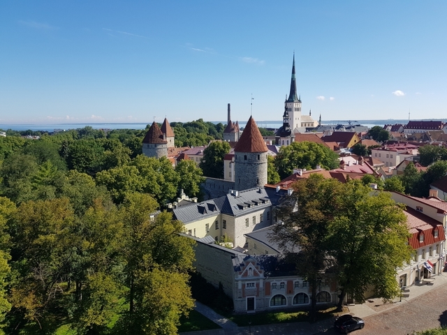       Aerial view of Tallinn with medieval towers and the sea.
  