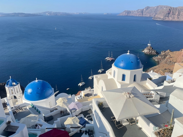 Iconic blue domes and whitewashed buildings overlooking the sea.