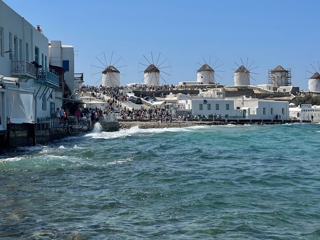 Scenic view of the famous windmills of Mykonos by the sea.