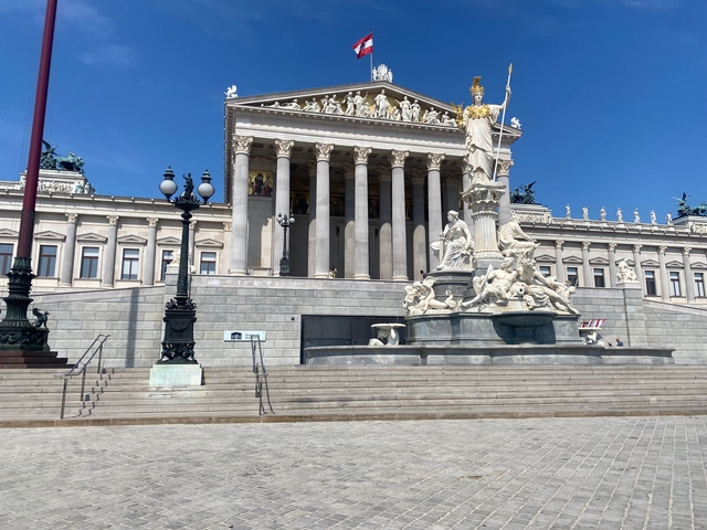 A grand historic building with a fountain in front.