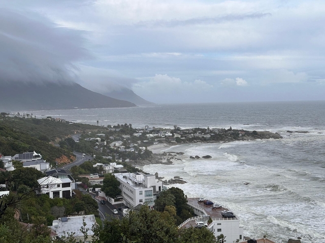 A view of the coastline with mountains and rocky shore.