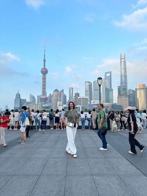People on a walkway with Shanghai skyline in the background.