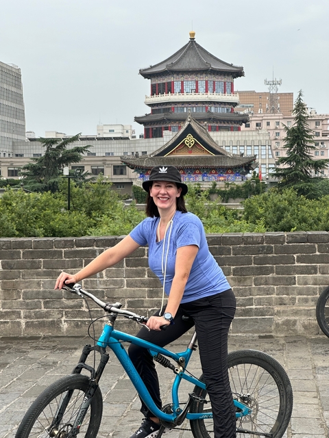 Person on a bike in front of historic architecture.