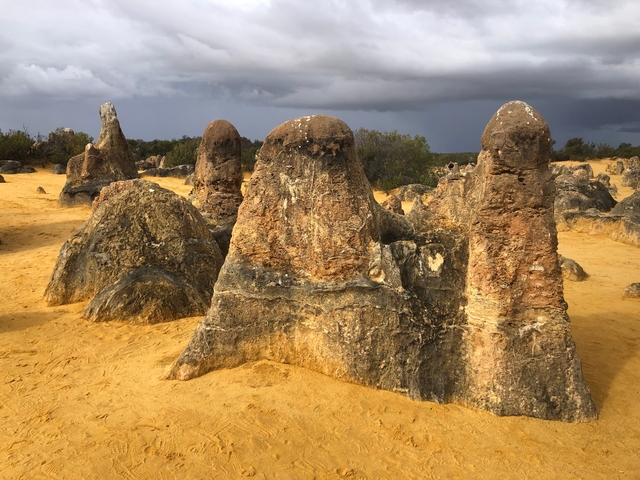 Rock formations in a desert landscape under cloudy sky.