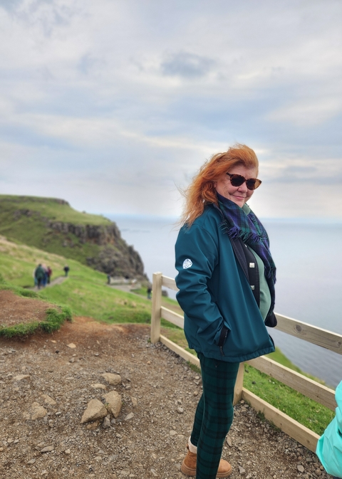A person with a scenic view of cliffs and the ocean.