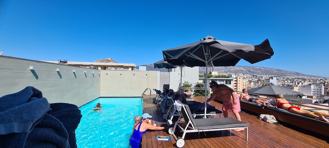       Rooftop pool with people and city view
  