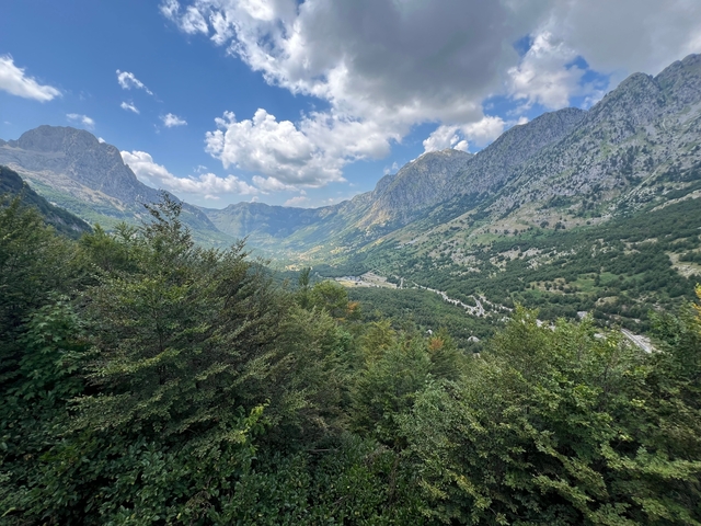 Mountain landscape with lush greenery and cloudy sky.