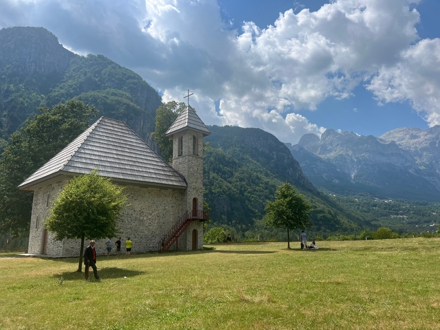 Stone church with mountains in the background.