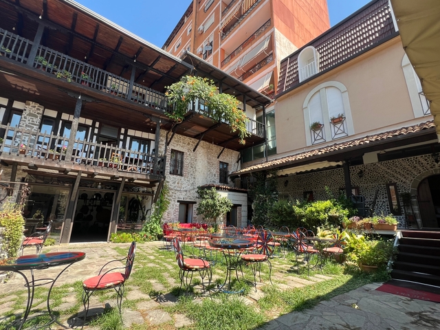 Courtyard with tables, chairs, and potted plants.