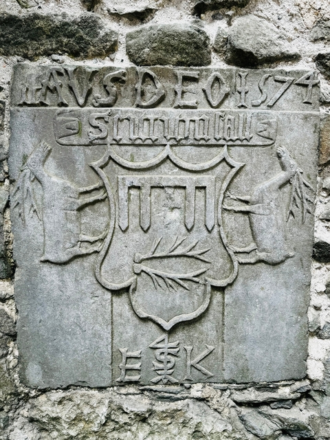       Engraved stone with historical motifs and symbols.
  
