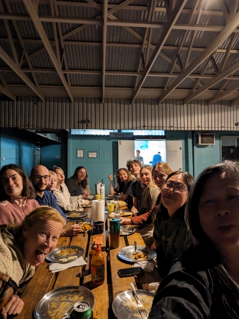       Group dining inside an informal setting with wooden decor.
  