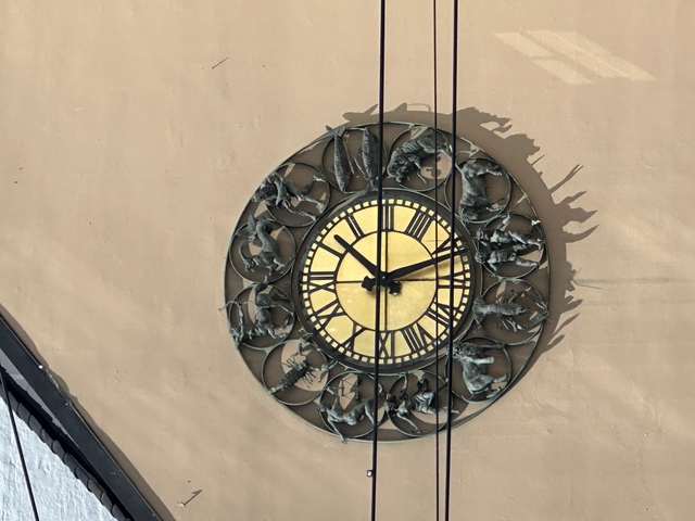      Decorative wall clock with intricate design and zodiac symbols.
  