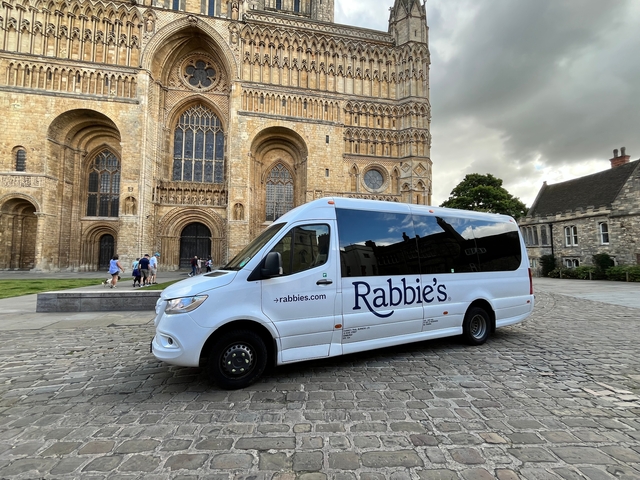 Tour bus parked in front of a historic cathedral.
