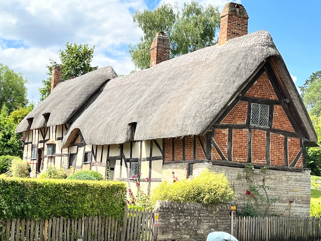       Thatched cottage surrounded by a garden.
  