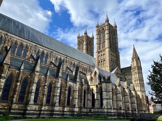Gothic cathedral with tall towers under a blue sky.