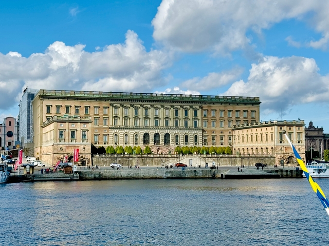       A royal palace by the water with a bright sky.
  