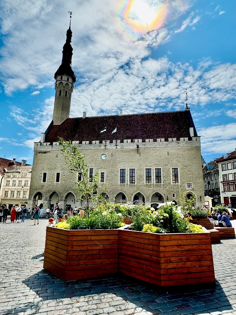 Historic building in a lively square with people.