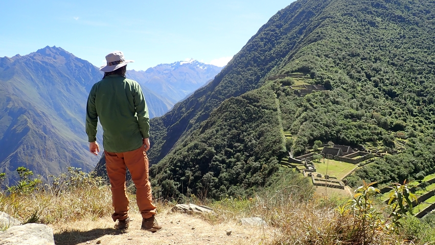 Person standing with a scenic view of Andean mountains.