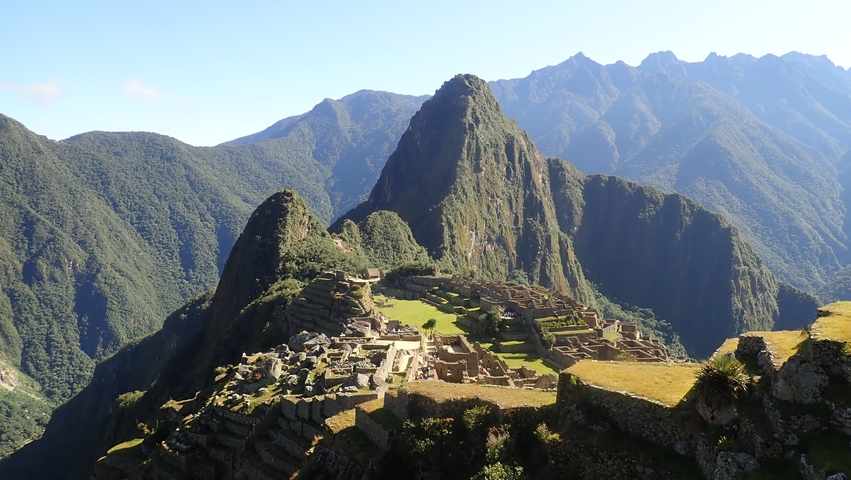 Panoramic view of Machu Picchu with surrounding mountains.
