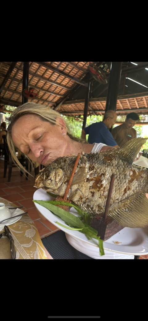 Woman interacting with a large fish dish.