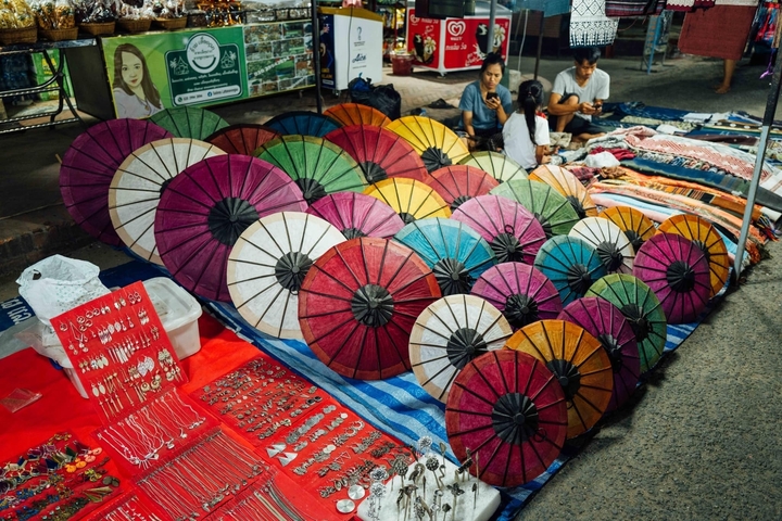 Colorful umbrellas and crafts at a market stall.