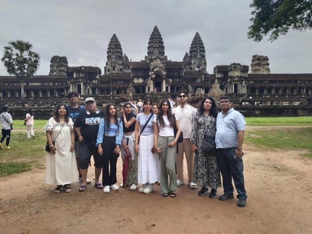 Group of people posing in front of the Angkor Wat temple.