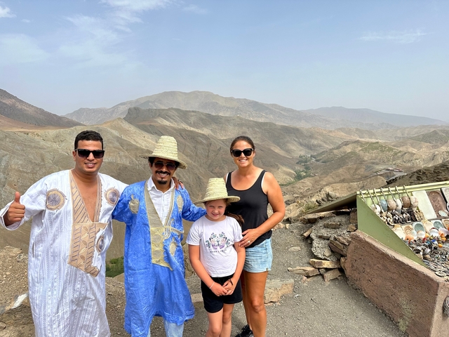       Group of people posing with traditional clothing in a mountainous area.
  