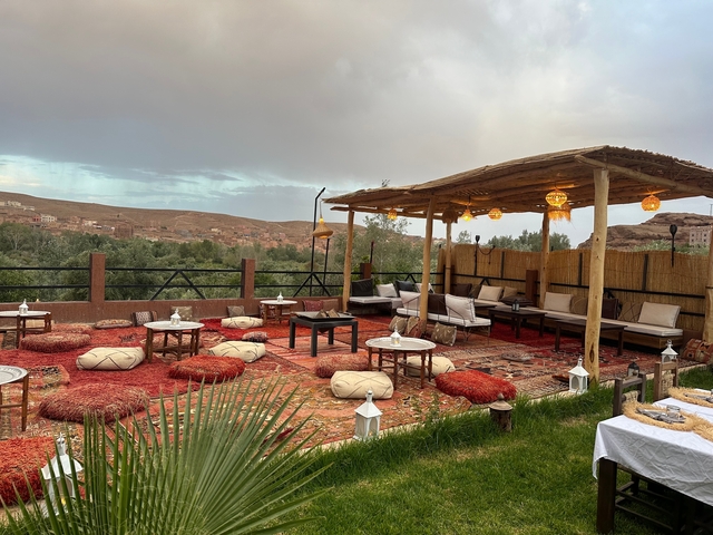       Traditional Moroccan outdoor seating area with rugs and cushions.
  