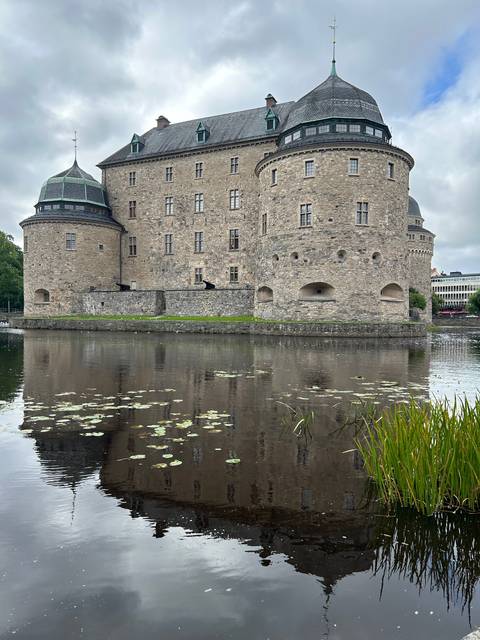 Medieval stone fortress with defensive towers and moat.