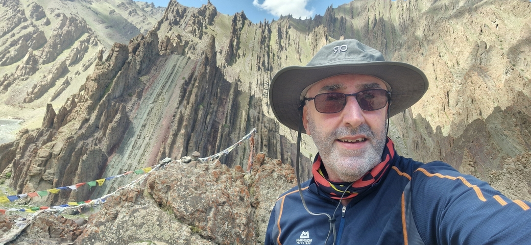 Selfie of a person hiking in a mountainous area.
