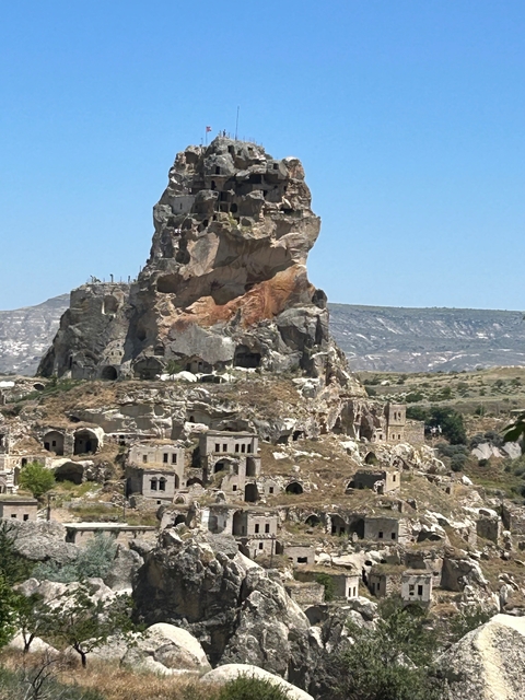 Ancient rock formations with caves and remnants of buildings.