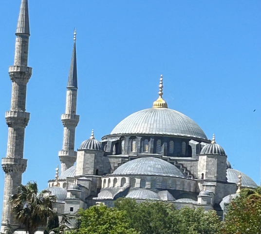 Blue mosque domes and minarets under clear blue skies.