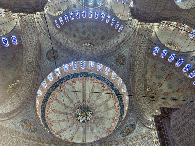 Ornate interior dome with intricate designs and windows.