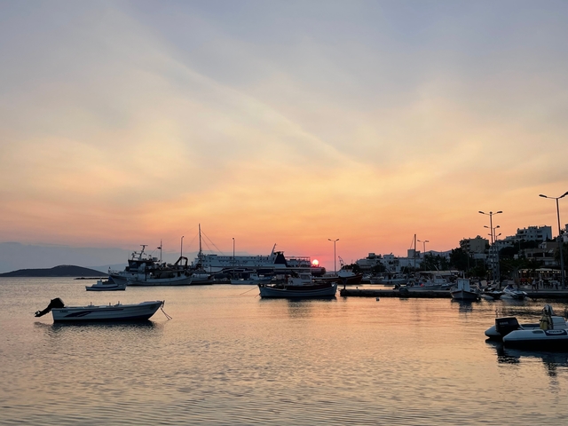       Sunset over a harbor with boats.
  