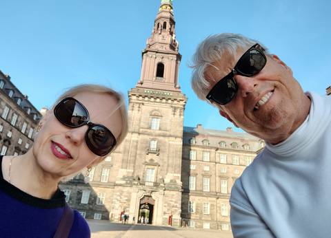 Selfie of two people with a historic building.