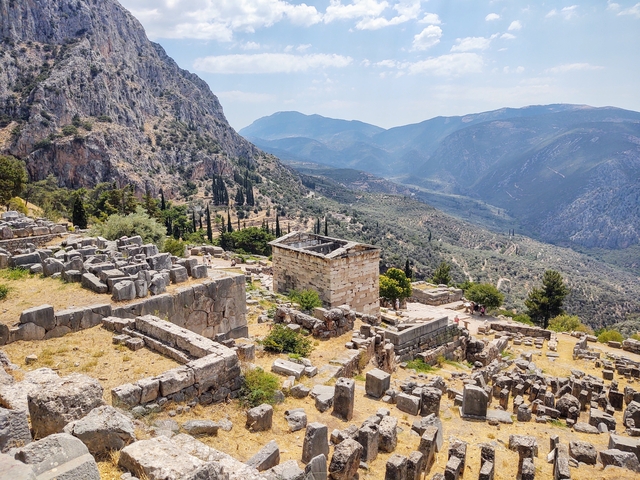 Ruins of an ancient site with a mountainous background.