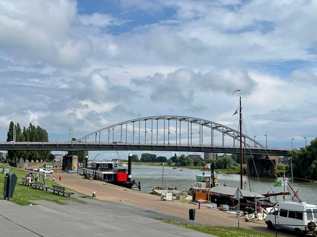 Panoramic view of a river with a large bridge.